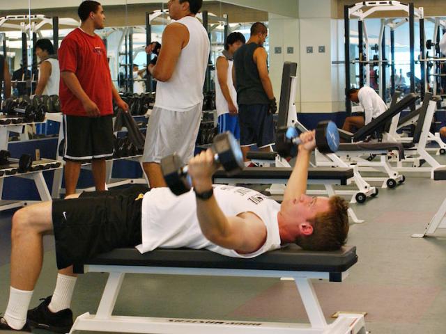A male student works out in the TV Activities and Recreation center weight room